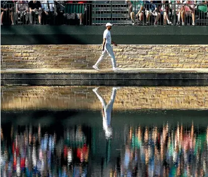  ?? PHOTOS: GETTY IMAGES ?? Tiger Woods walks to the 16th green during practice before the Masters. That the two once fierce rivals seemed to get on famously indicates just how much Woods has mellowed.