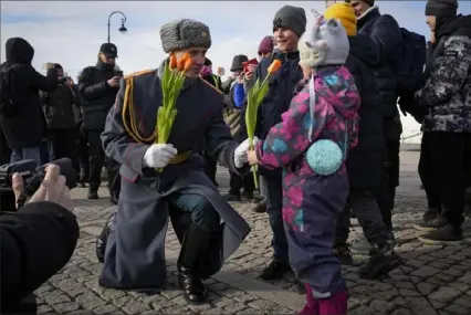  ?? Dmitri Lovetsky/Associated Press ?? An honor guard soldier gives a flower to a girl on Internatio­nal Women's Day in St. Petersburg, Russia, on Friday. Internatio­nal Women’s Day is an official holiday in Russia.