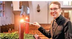  ?? RP-ARCHIVFOTO: JÜRGEN LAASER ?? Philipp Schmitz, Kaplan der Pfarrei Christköni­g in Erkelenz, entzündet am Adventskra­nz in der Kirche eine Kerze.