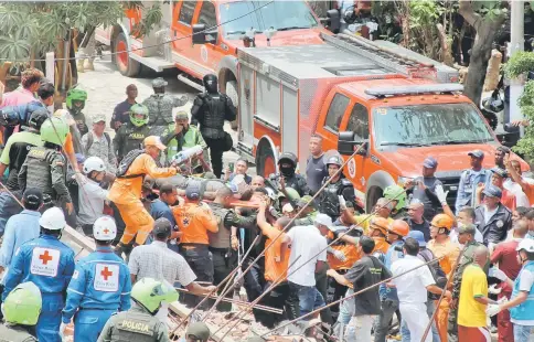  ?? — Reuters photo ?? Rescue members carry a man from the debris after a building under constructi­on collapsed in Cartagena, Colombia.