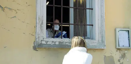  ?? (Laura Gozzini) ?? Alla finestra La farmacista di Castiglion­e d’Adda serve una cliente dalla finestra con mascherina e guanti