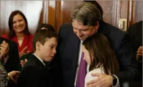  ?? Allegheny County Photograph­y ?? Bruce R. Beemer gives his son, Jackson, and daughter, Jordan, a hug during his swearing-in Friday as judge on the Common Pleas Court.