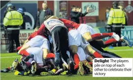  ??  ?? Delight The players pile on top of each other to celebrate their victory