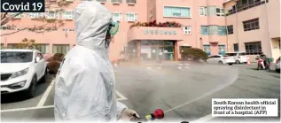 ??  ?? South Korean health official spraying disinfecta­nt in front of a hospital. (AFP)