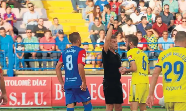  ??  ?? El árbitro muestra tarjeta amarilla a José Mari durante el transcurso del encuentro entre el Extremadur­a y el Cádiz.