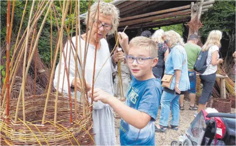  ?? FOTOS: SUSANNE GRIMM ?? Das Korbflecht­en ist gar nicht so einfach – das stellt auch dieser Junge fest.