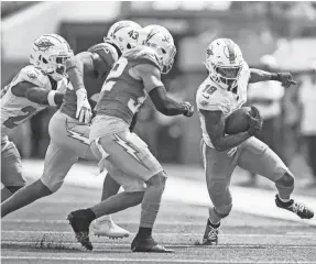  ?? ?? Miami Dolphins wide receiver Erik Ezukanma (18) runs with the ball past Los Angeles Chargers cornerback Michael Davis (43) and safety Alohi Gilman (32) on Sunday in Inglewood, Calif.