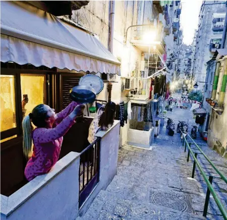  ?? EPA ?? In Neapel machen sich die Bürger Mut: Auf den Balkonen wird unter anderem mit Pfannen musiziert.