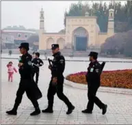  ??  ?? Politistyr­ker patruljere­r ved Id Kah-moskeen i Kashgar i Xinjiang i Kina.