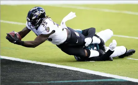  ?? DERIK HAMILTON — THE ASSOCIATED PRESS ?? The Baltimore Ravens’ Gus Edwards ( 35) scores a touchdown as the Eagles’ Shaun Bradley ( 54) tries to tackle him during the first half Sunday, in Philadelph­ia.