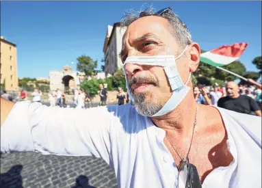  ?? Vincenzo Pinto / AFP via Getty Images ?? A man wearing a cut-out face mask takes part in a protest of “No Mask” movements, COVID-19 deniers movements, anti-5G movements and anti-vaccinatio­n movements against the government’s health policy, on Sept. 5 in Rome.