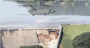  ?? DANNY LAWSON ?? A ROYAL Air Force Chinook helicopter dropped sacks of ballast yesterday on to the outer slope of a dam that had partially collapsed and is at risk of bursting and flooding the town of Whaley Bridge in Derbyshire, UK. British police ordered the evacuation of the town of 6 500 people over fears that the rain-damaged wall could collapse. | PA via AP