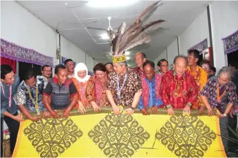  ??  ?? Awang Tengah (sixth left) and Dayang Morliah (fourth left) join Tuai Rumah Munit Entalang (fifth left) and others in rolling a mat to mark the closing of Gawai Dayak.