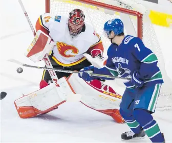  ??  ?? Canucks forward Jayson Megna tips the puck past Flames goalie Mike Smith and into the net, but it was called no goal due to a high stick.