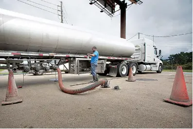  ?? Staff photo by Evan Lewis ?? n David Cook, with Central Arkansas Petroleum Transport, delivers a half tanker load of fuel Thursday afternoon to the E-Z Mart at Interstate 30 and State Line Avenue. The Texas Railroad Commission tweeted, “There is no fuel shortage.” Officials from...