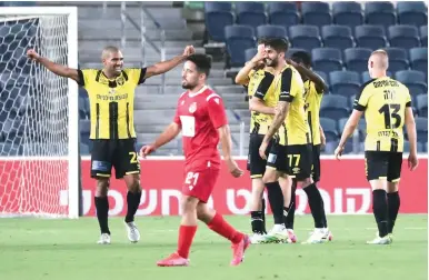 ?? (Danny Maron) ?? BEITAR JERUSALEM celebrates after earning a 3-1 victory over Hapoel Tel Aviv on Saturday night at Teddy Stadium. It was the yellow-and-black’s first conquest of the Championsh­ip Playoffs and it clinched a spot in Europa League qualifying.