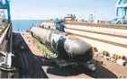  ?? MATT HILDRETH/HII ?? Newport News Shipbuildi­ng workers transfer the submarine Montana to a floating drydock.
