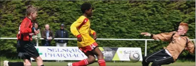  ??  ?? Festy Ebosele skips between Jason Bolger and netminder Alan Hayes to score one of his three goals for Moyne Rangers.