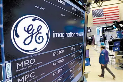  ?? AP ?? The General Electric production jobs. logo is displayed at the New York Stock Exchange earlier this year. GE’s power division is shedding office and