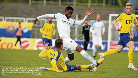  ??  ?? Hart geführt wurden die Duelle beim Spiel des FC Carl Zeiss gegen Lok Leipzig. Hier grätscht Lok-Kapitän Markus Krug gegen Jenas Torschütze­n Bedi Buval. Foto: Corbus