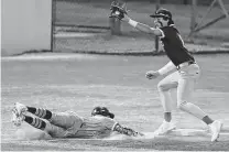  ?? ?? Reagan's Teagan Peeples gets Johnson's Rohan Naik out at third base on Friday night.