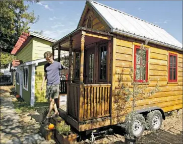  ?? Ben Margot Associated Press ?? JAY SCHAFER exits a tiny house he built for himself in Sonoma County. San Diego city officials say they plan to amend the municipal code to allow property owners to install and rent out the small homes on wheels.