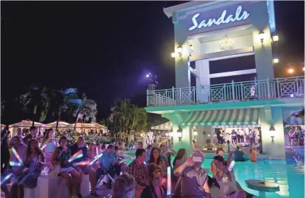  ?? GUSTAVO CABALLERO/GETTY IMAGES FOR SANDALS RESORTS ?? Revelers gather at Sandals Ochi Beach Resort in Ocho Rios, Jamaica, in June 2015 after the resort’s grand opening.