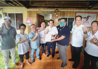  ?? ?? Lee (fifth left) and others pose during the handover of the offer le er by Zaid Iskandar (third right) to chieftain Bangau Nyambar.