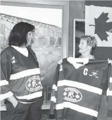  ?? NICK BRANCACCIO ?? Riverside Minor Hockey Associatio­n president Anne Marie Schofield, left, presents a jersey Saturday to Theresa Charbonnea­u, whose son Andrew Grenon, an RMHA alumnus, was killed in Afghanista­n.