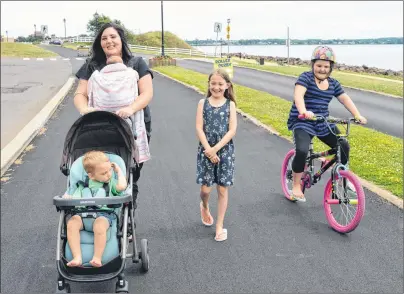  ?? DAVE STEWART/THE GUARDIAN ?? Kayla Hainer, pushing the stroller, found out the hard way that she’s allowed to push her child in a stroller on the cycling lane at Charlottet­own’s Victoria Park as long as her other daughter is on her bicycle beside her. Hainer said she was accosted by a cyclist on Tuesday night for being on the cycling lane with a stroller. Also pictured are her son, Brayden Thompson (in the stroller), her daughter, Blake Thompson (in the baby holder), her daughter, Trinity Hainer (on the bicycle) and Chloe Coggar (walking), a child Hainer babysits.