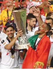  ?? — AP ?? Sevilla players celebrate with the trophy after winning the Europa League final against Inter Milan in Cologne, Germany, on Friday.