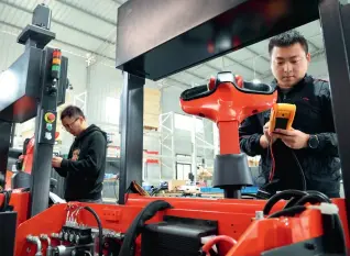  ?? ?? Des employés de l’entreprise Zouda Robot testent les véhicules à guidage automatiqu­e (VGA) à Chongqing, le 8 octobre 2023.