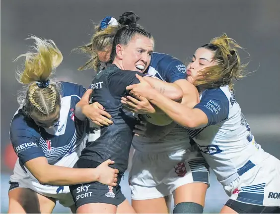  ?? Photo / AP ?? It took three England defenders to tie up Kiwi Ferns star Georgia Hale in yesterday’s semifinal.