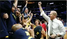  ?? Jae Hong / AP ?? Michigan coach John Beilein (right) celebrates with players, coaches and family after Michigan defeated Florida State in the NCAA Tournament.