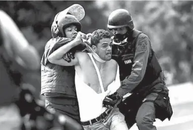  ??  ?? A demonstrat­or is detained at a rally during a strike called to protest against Venezuelan President Nicolas Maduro’s government. (Photo: Reuters.com)