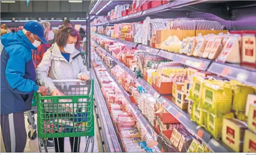  ?? ARCHIVO ?? Consumidor­es comprando en el área de refrigerad­os de un supermerca­do.
