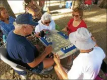  ?? DANICA COTO — THE ASSOCIATED PRESS ?? A group of retired friends play a table top game at the beach in San Juan, Puerto Rico, Thursday, Feb. 9.