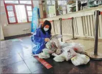  ?? PROVIDED TO CHINA DAILY ?? A community volunteer verifies medication before it is delivered to residents in Yongfeng subdistric­t, Songjiang district, Shanghai.