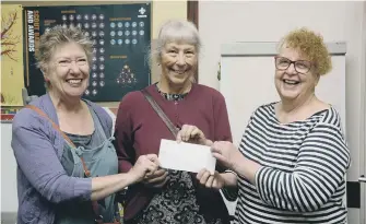  ?? ?? From left: Lizzie Sky Hall and Sharon Hodgson from the SJT shop present a cheque to Sue Wilson of the Fridge.