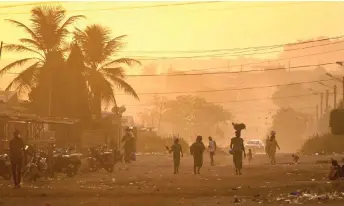  ?? — AFP photos ?? People walk in a street in korhogo, northern Ivory Coast. While the explosion of debt is throwing a shadow over global economic growth, experts warn that sub-Saharan Africa, where several countries are already in default, is experienci­ng its worst-ever crisis.