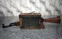  ??  ?? A custom-built lute made from a Kalashniko­v assault rifle and an ammunition box on display on the floor at the home of Iraqi musician Majed Abdennour.