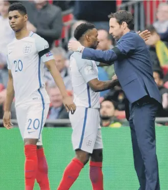  ??  ?? England boss Gareth Southgate congratula­tes Jermain Defoe on his efforts, following his substituti­on