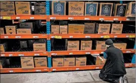  ?? ZBIGNIEW BZDAK/CHICAGO TRIBUNE ?? Marcos Nevarez checks cleaning supplies at Banner Wholesale Grocers warehouse.