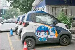  ?? JADE GAO/AGENCE FRANCE-PRESSE ?? MINI electric cars are parked outside a police station in Liuzhou, in southern China’s Guangxi province. Tiny electric cars weave through traffic, their cheap and cheerful designs bringing a touch of color to the EV revolution in the country’s overlooked cities.