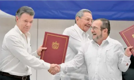  ?? /GETTY IMAGES ?? El presidente de Colombia, Juan Manuel Santos (i) y Rodrigo Londoño ‘Timochenko’ (d), se dan la mano durante los acuerdos de paz de La Habana (Cuba).