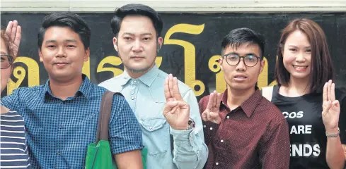  ??  ?? Piyarat Chongthep, second from right, Jirawat Ekakaranuw­at, centre, and Songtham Kaewphanpr­uek, second from left, make a three-finger sign as they show up for an Appeal Court ruling in a ballot-tearing case involving the Aug 7, 2016 charter referendum.