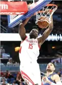  ?? John Raoux/Associated Press ?? ■ Houston Rockets' Clint Capela (15) dunks over Orlando Magic's Nikola Vucevic (9) during the first half of an NBA game, Sunday in Orlando, Fla.