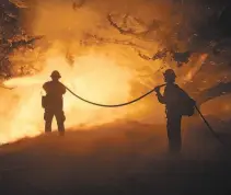  ??  ?? Firefighte­rs hose down the Dolan Fire, which ignited Aug. 18 near Limekiln State Park.