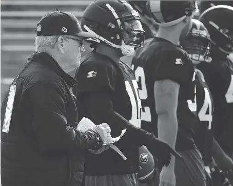  ?? ALLIANCE OF AMERICAN FOOTBALL/VIA AP ?? Bill Polian, Alliance of American Football head of football and co-founder, left, watches as players with the Birmingham Iron practise in San Antonio. Polian’s new league, featuring eight teams of 52 players, kicked off its inaugural season over the weekend.