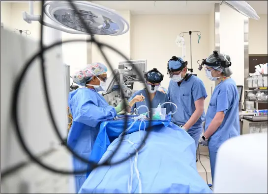  ?? RJ SANGOSTI — THE DENVER POST ?? Medical workers perform an outpatient surgery at Denver Health on Wednesday. Hospitals’ profits fell in 2022 as their revenues from treating patients rose, but their expenses soared as they had to spend more on salaries, including costlier travel nurses, to get and keep workers and more on supplies.